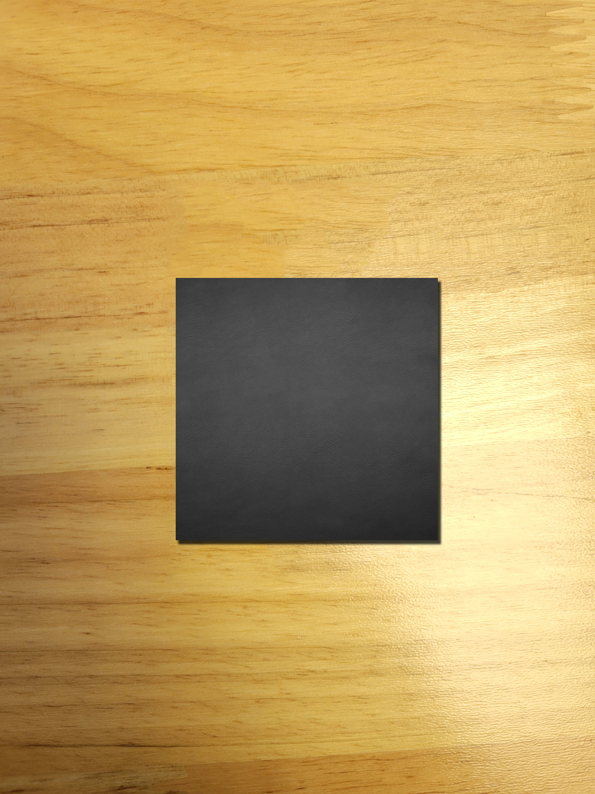 A black square is sitting on a wooden table.