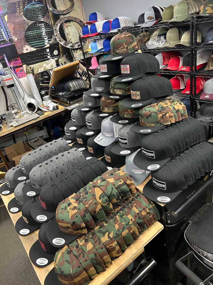 A bunch of hats are stacked on top of each other on a table in a store.