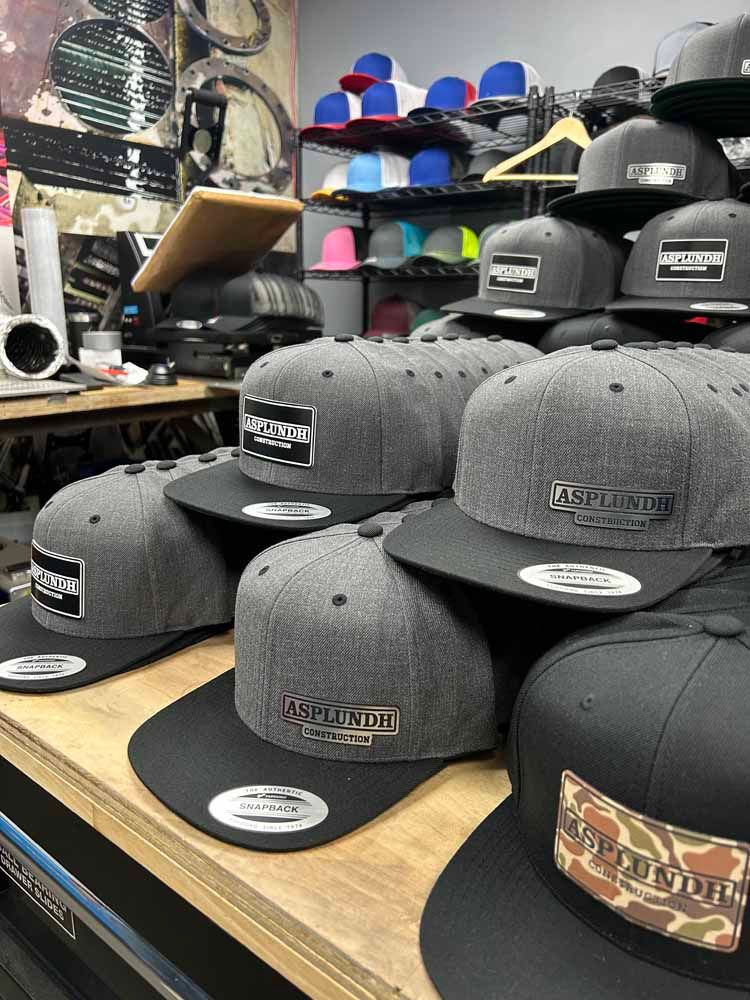 A bunch of hats are stacked on top of each other on a wooden table.