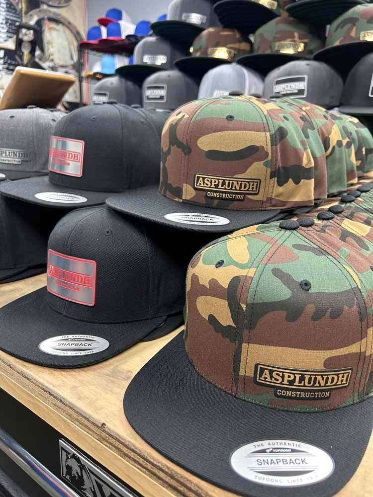 A bunch of hats are sitting on top of a wooden table.