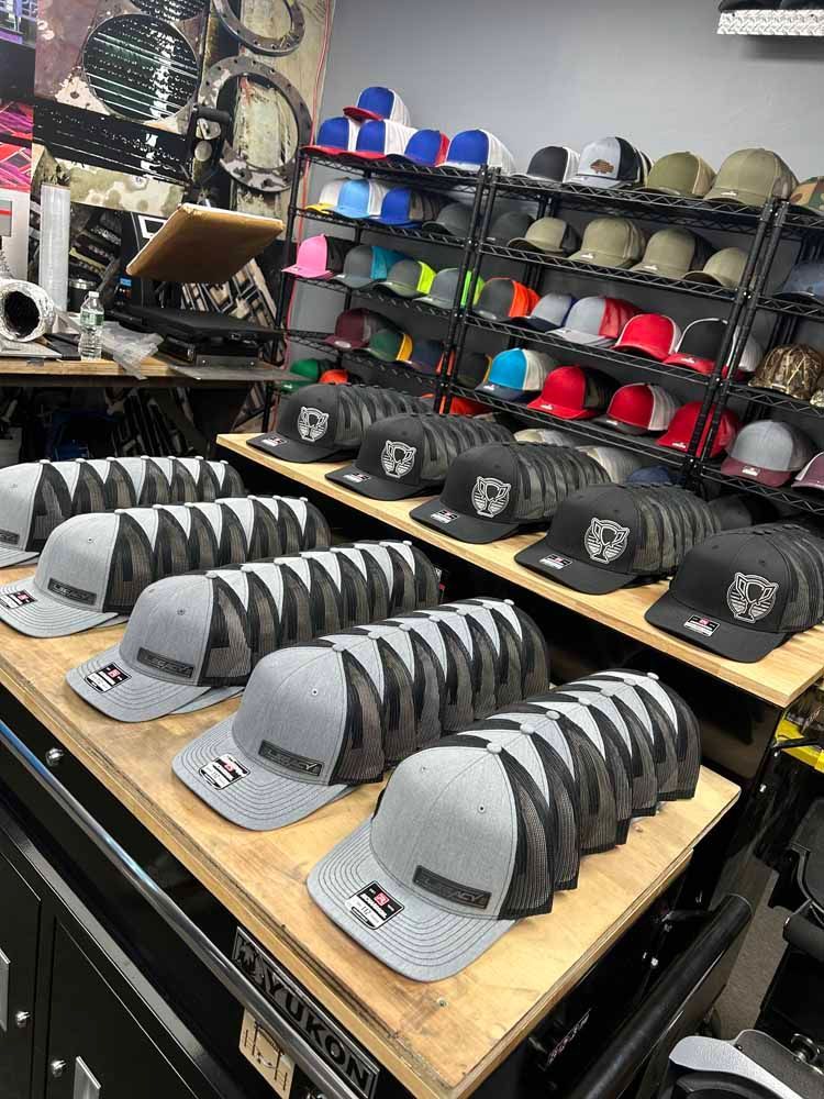 A bunch of hats are sitting on a wooden table in a store.