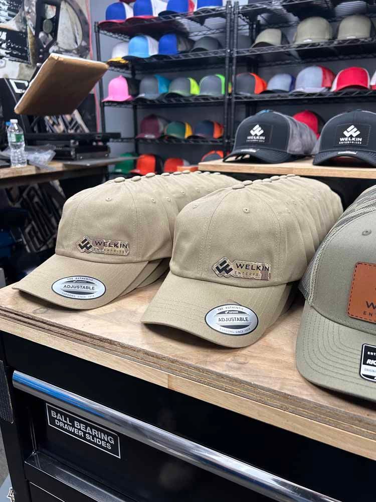 A bunch of baseball caps are sitting on a wooden shelf in a store.