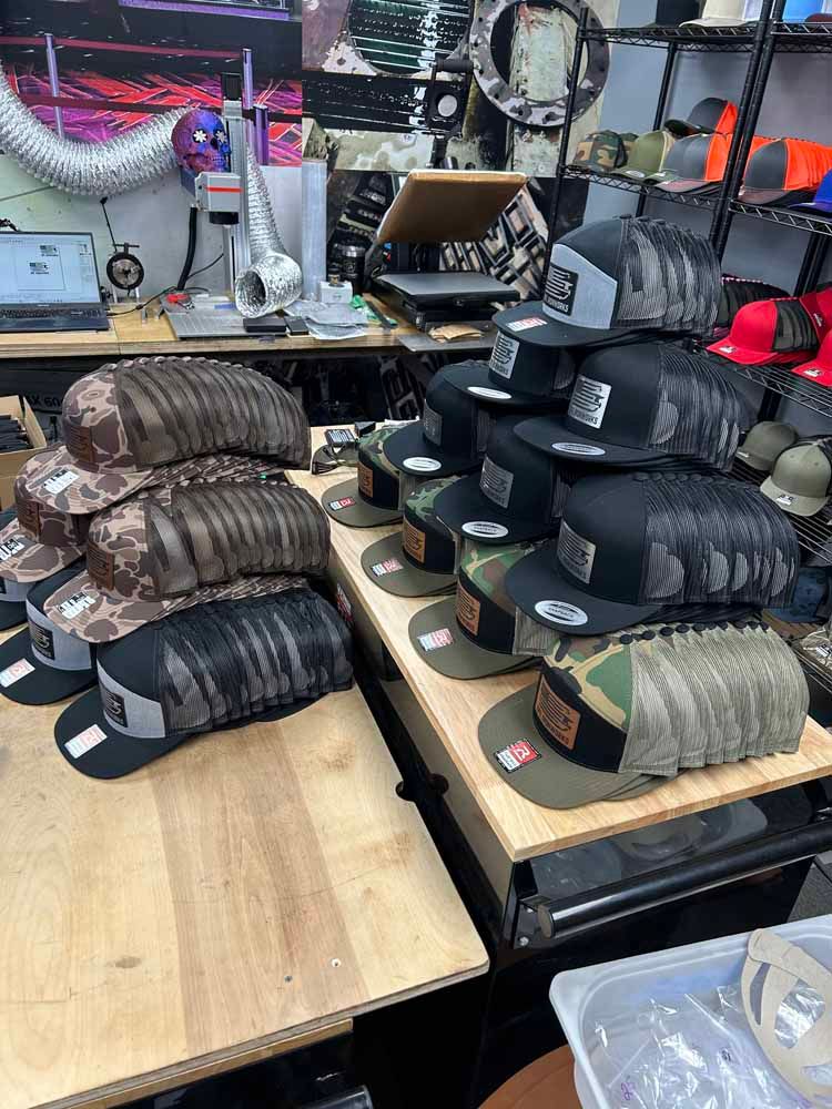 A bunch of hats are stacked on top of each other on a wooden table.