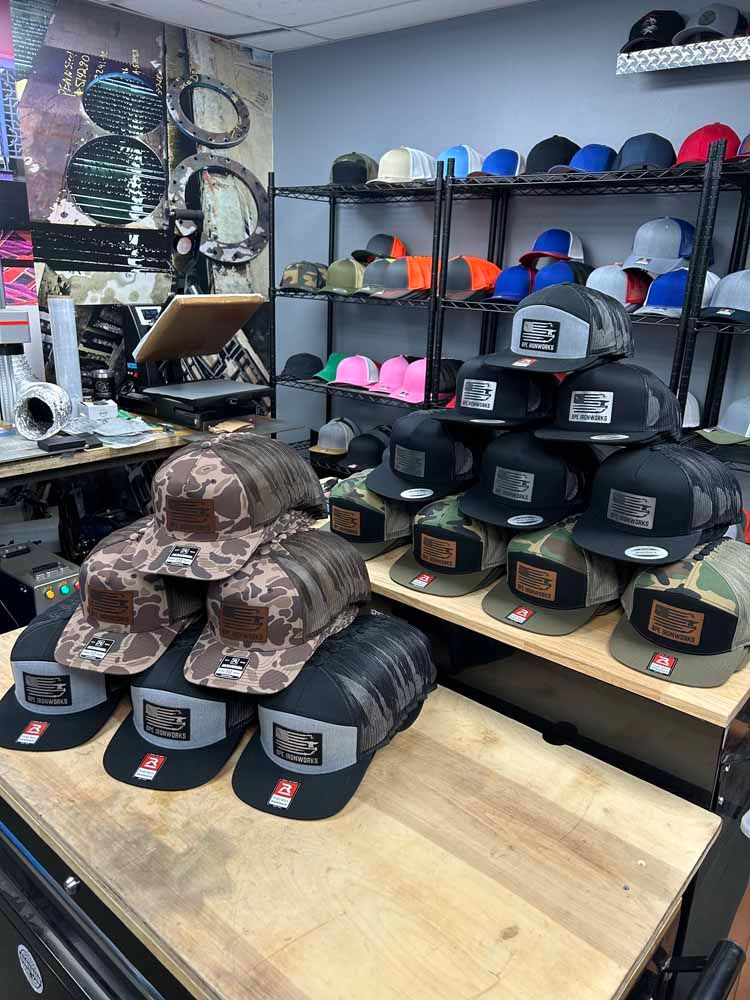 A bunch of hats are stacked on top of each other on a table in a store.