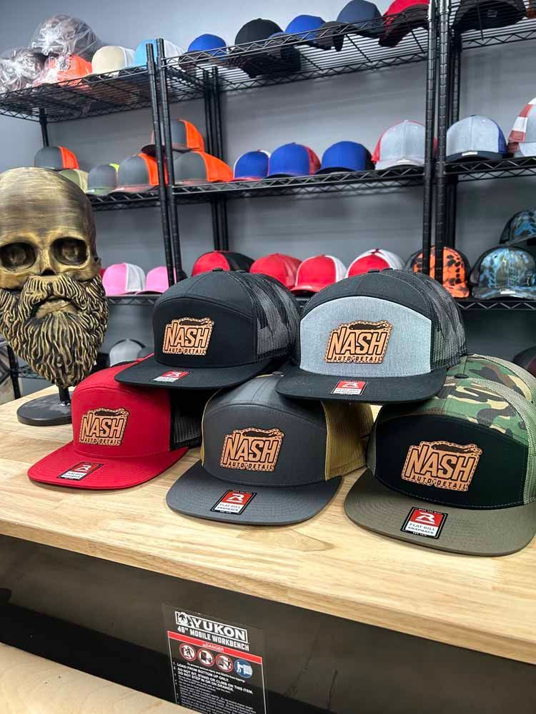 A bunch of hats are sitting on top of a wooden table.