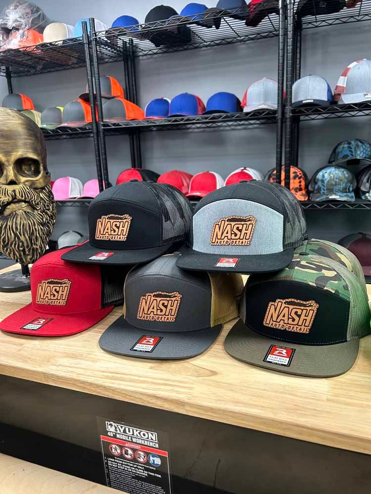 A bunch of hats are sitting on top of a wooden table in a store.
