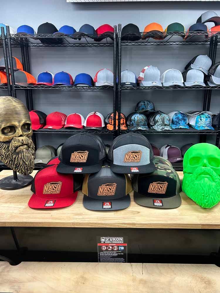 A bunch of hats are sitting on top of a wooden table in a store.