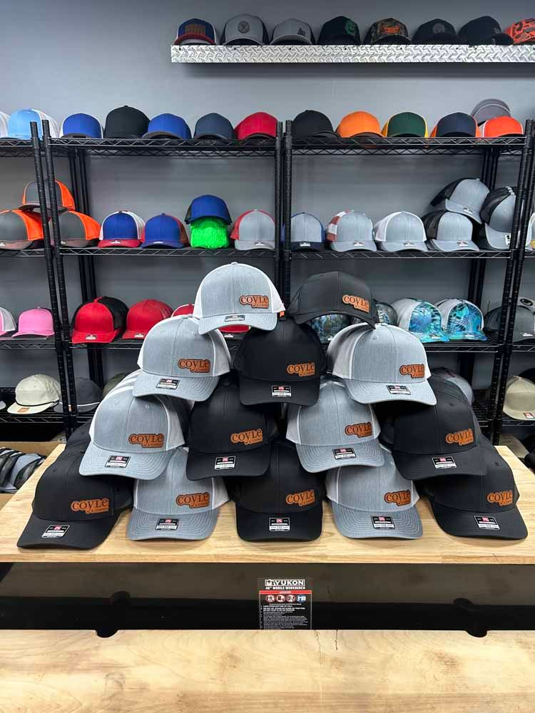 A bunch of hats are stacked on top of each other on a table in a store.