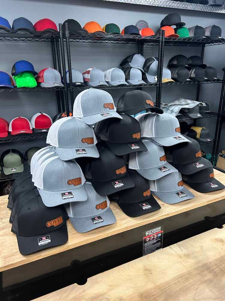 A bunch of hats are stacked on top of each other on a table in a store.