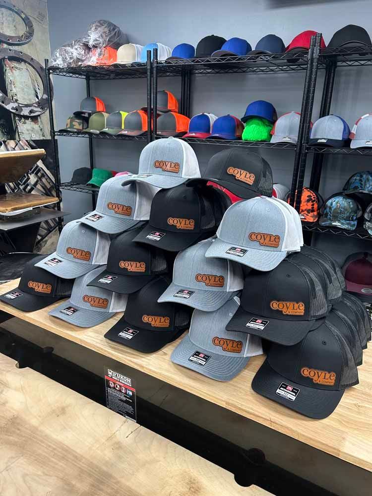 A bunch of hats are stacked on top of each other on a shelf in a store.