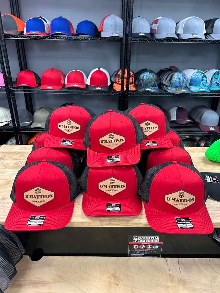 A bunch of red hats are sitting on top of a wooden table.