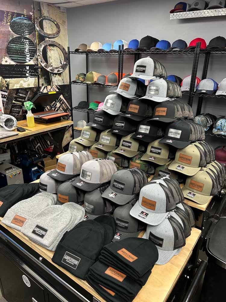 A bunch of hats are stacked on top of each other on a table in a store.
