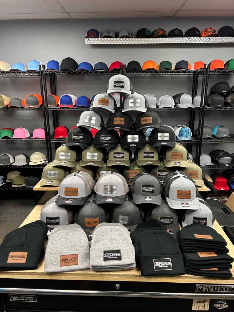 A bunch of hats are stacked on top of each other on a table in a store.