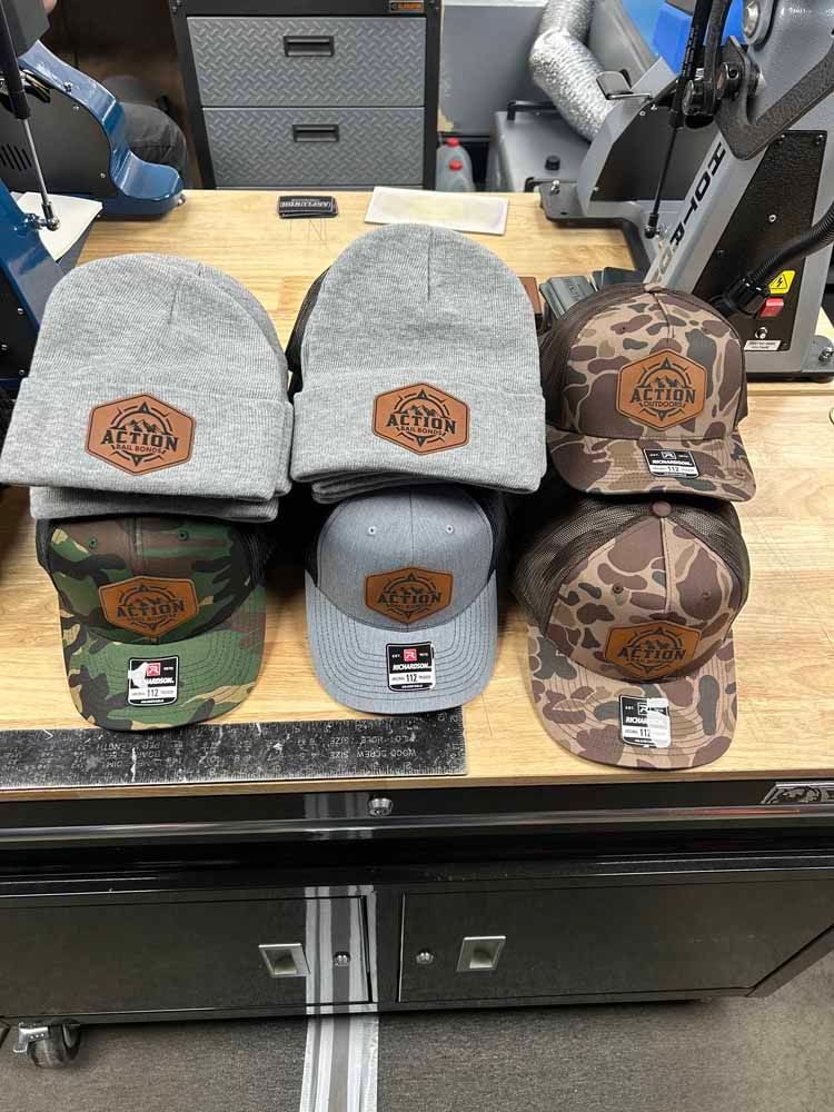 A bunch of hats are sitting on top of a wooden table.