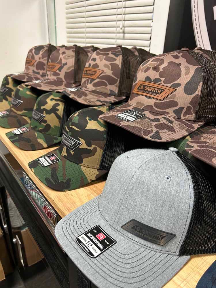 A row of hats sitting on top of a wooden table.