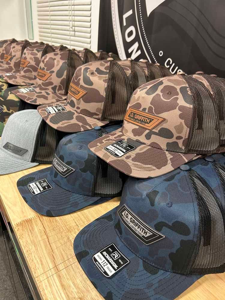 A bunch of hats are sitting on top of a wooden table.