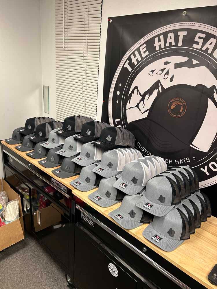 A bunch of hats are sitting on a table in front of a sign that says the hat shop.