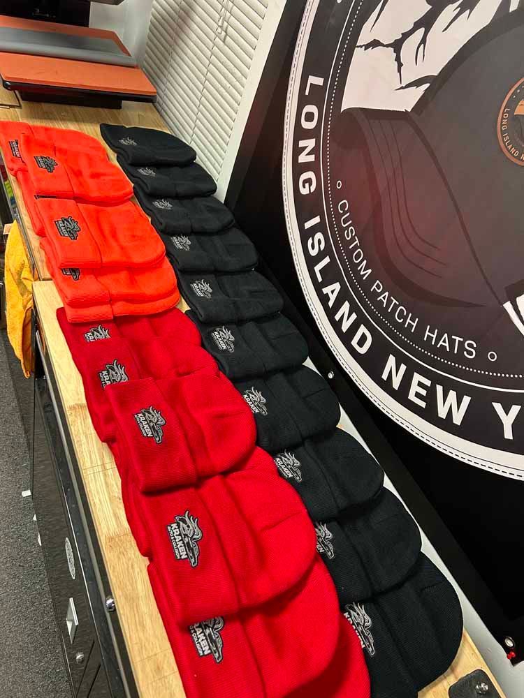 A bunch of hats are sitting on a table in front of a sign that says long island new york