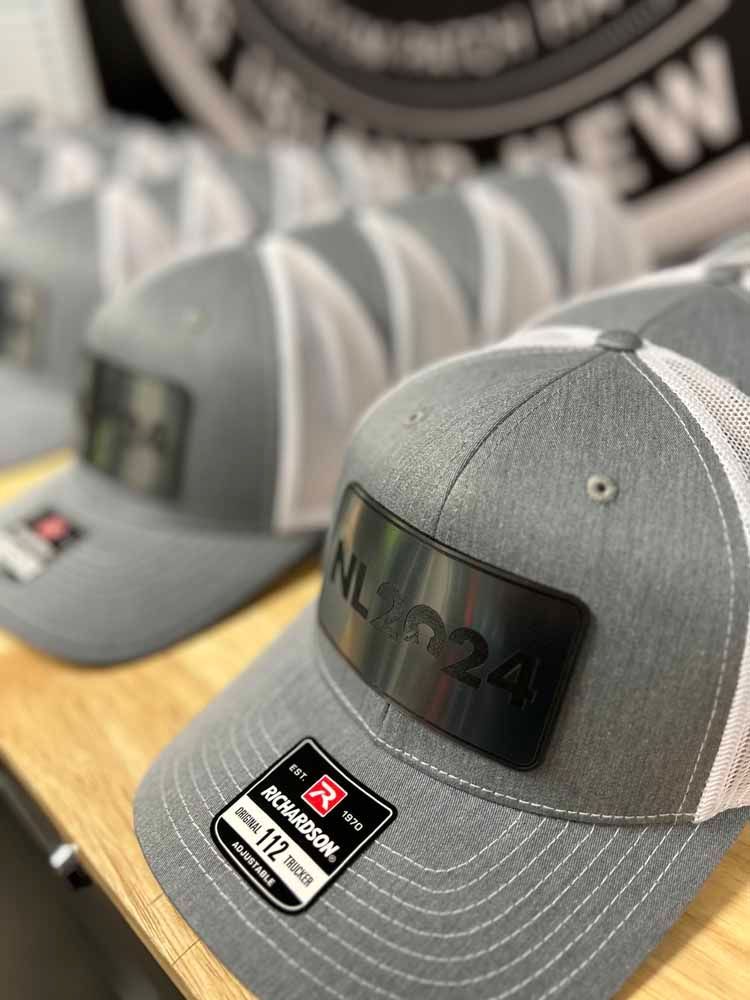 A row of baseball caps are sitting on a wooden table.