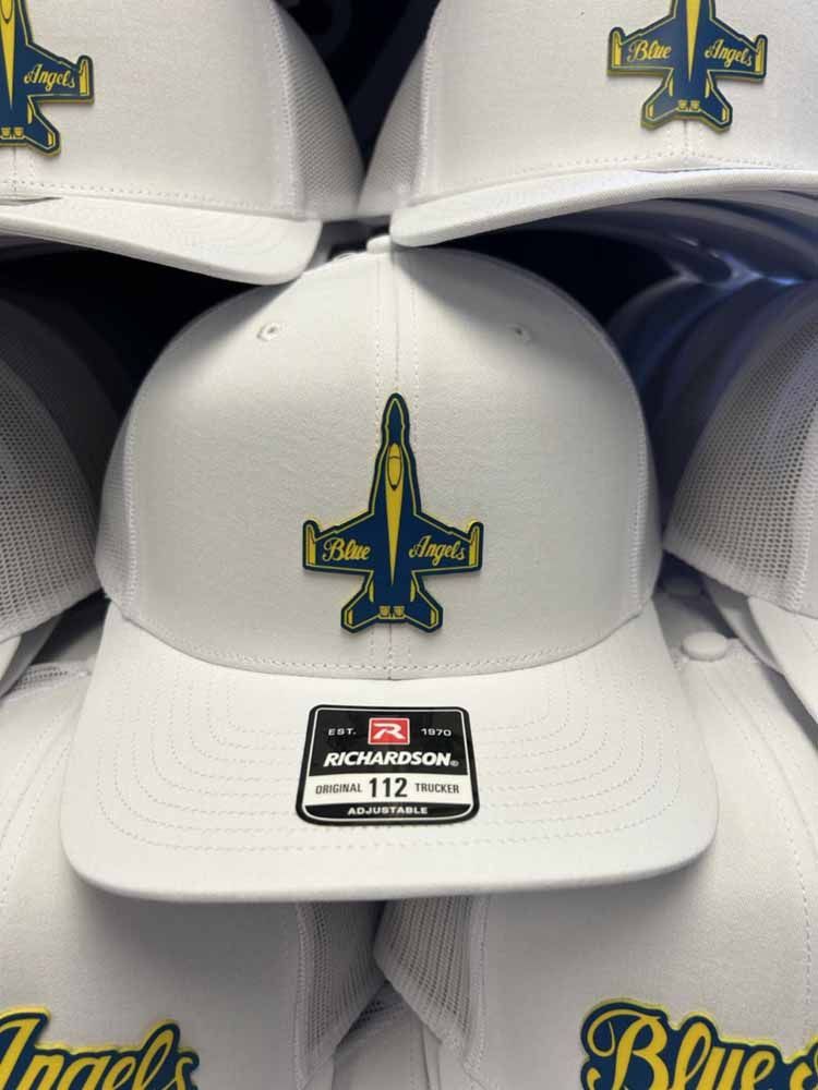 A stack of white hats with a blue and yellow airplane on them