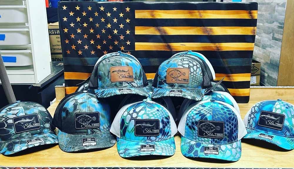 A bunch of hats are sitting on a table in front of an american flag.