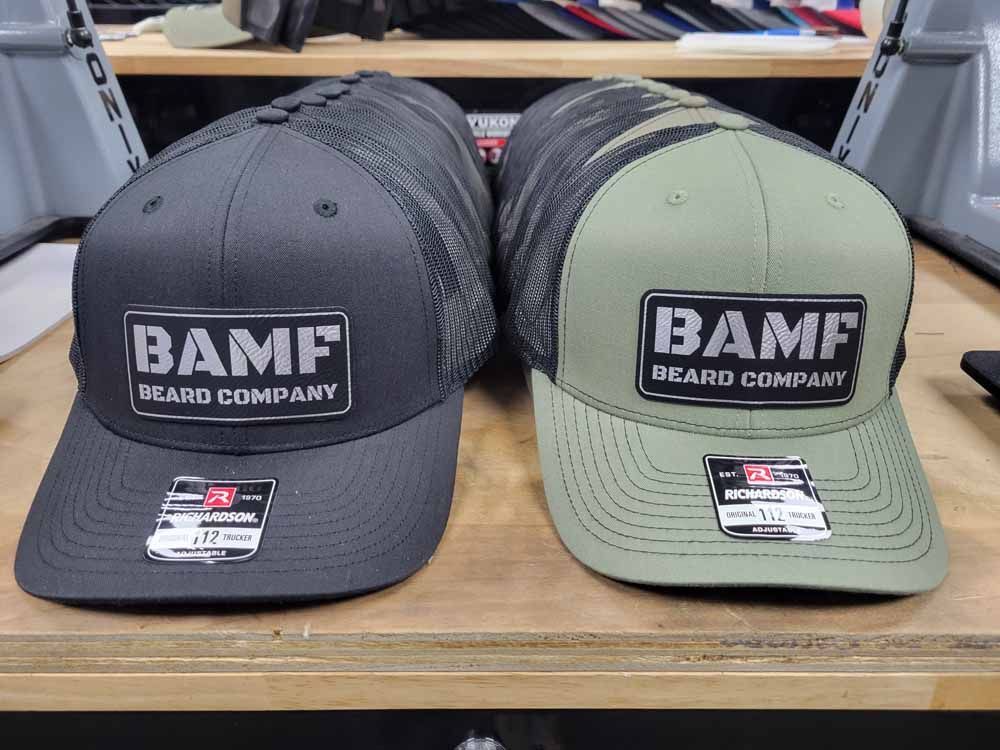 Two bamf hats are sitting on a wooden shelf.