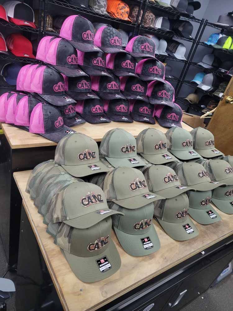 A bunch of hats are stacked on top of each other on a table in a store.