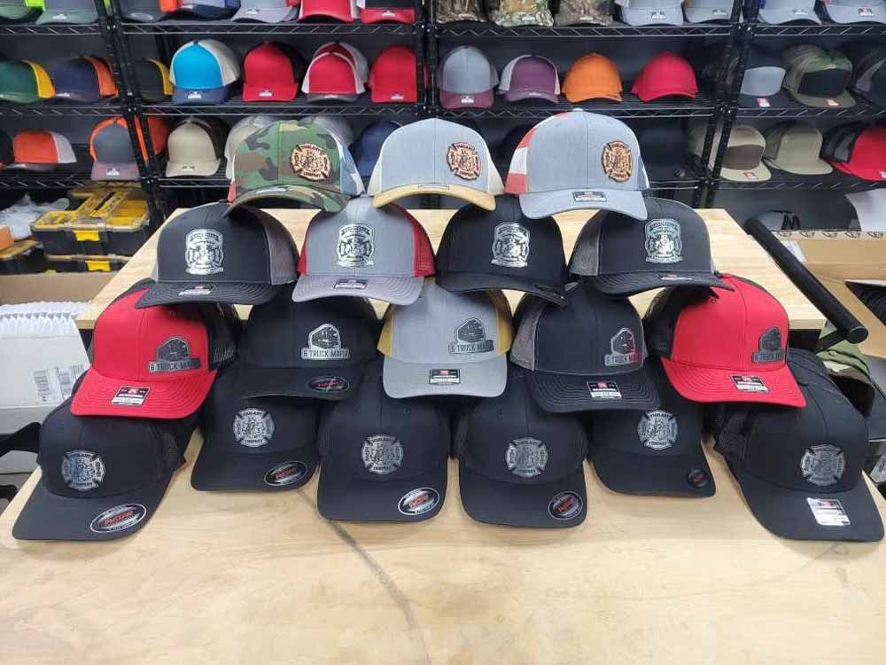 A bunch of baseball caps are stacked on top of each other on a table.
