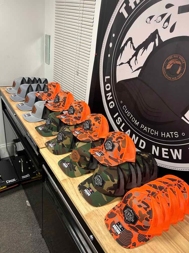 A bunch of hats are sitting on a wooden table.