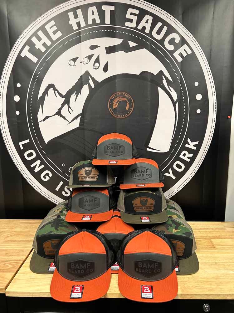 A bunch of hats are stacked on top of each other in front of a logo for the hat sauce york.