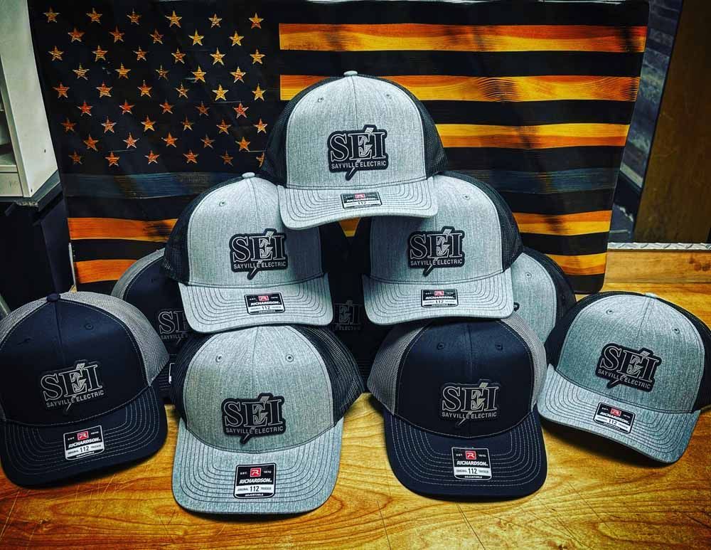 A bunch of hats are stacked on top of each other in front of an american flag.