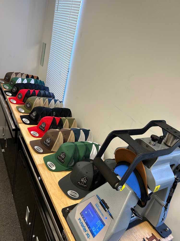 A row of hats sitting on top of a table next to a machine.