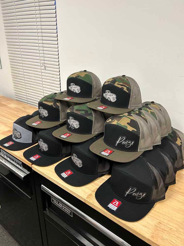 A bunch of hats are stacked on top of each other on a wooden table.