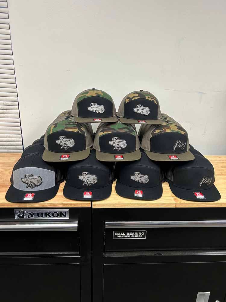 A bunch of hats are stacked on top of each other on a wooden table.