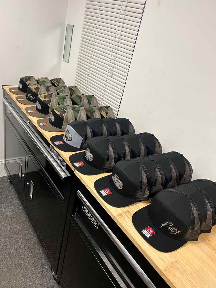 A row of hats sitting on top of a wooden table.