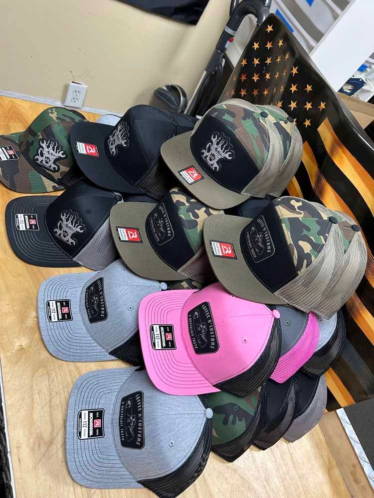 A bunch of hats are stacked on top of each other on a wooden table.