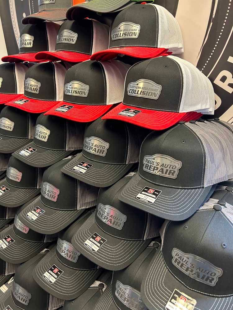 A bunch of hats are stacked on top of each other on a shelf.