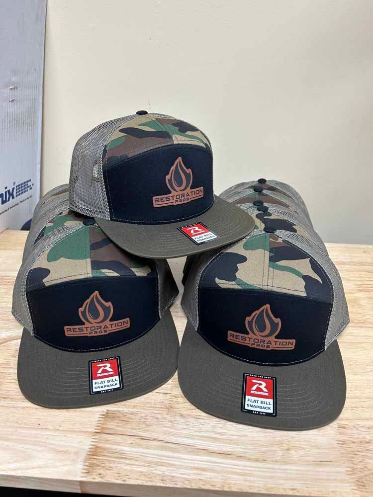 Three hats are stacked on top of each other on a wooden table.