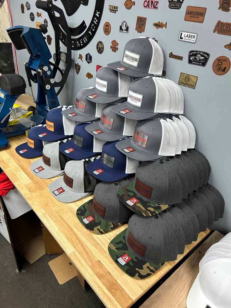A bunch of hats are stacked on top of each other on a wooden table.