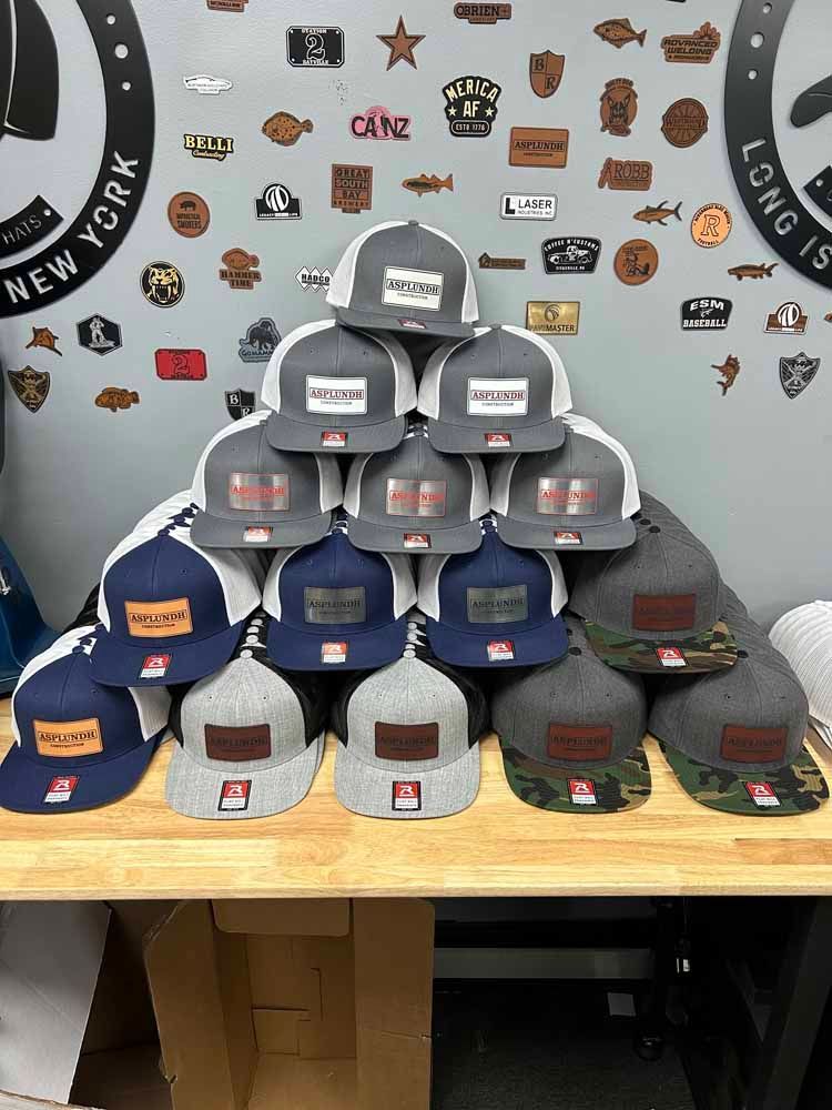 A bunch of hats are stacked on top of each other on a wooden table.