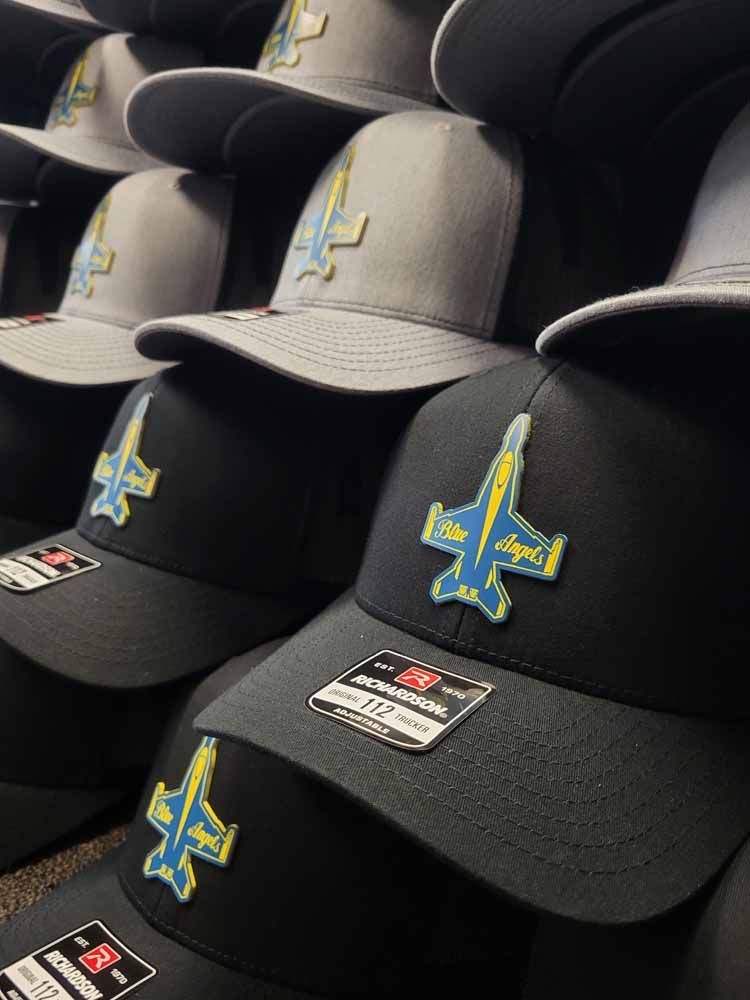 A bunch of baseball caps are stacked on top of each other.