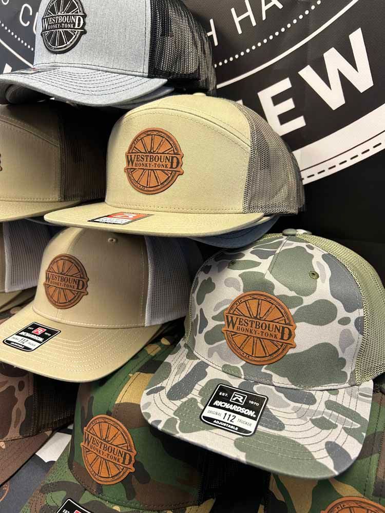 A bunch of hats are sitting on top of each other on a shelf.