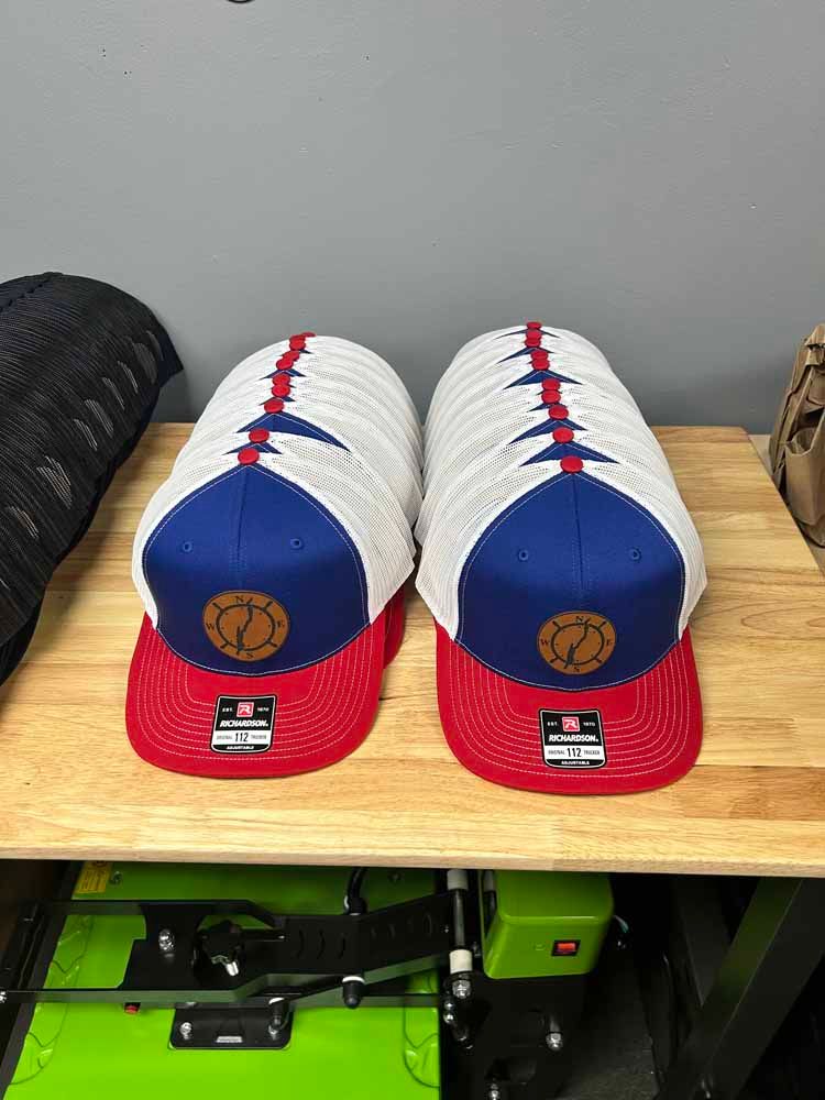 A stack of hats sitting on top of a wooden table.