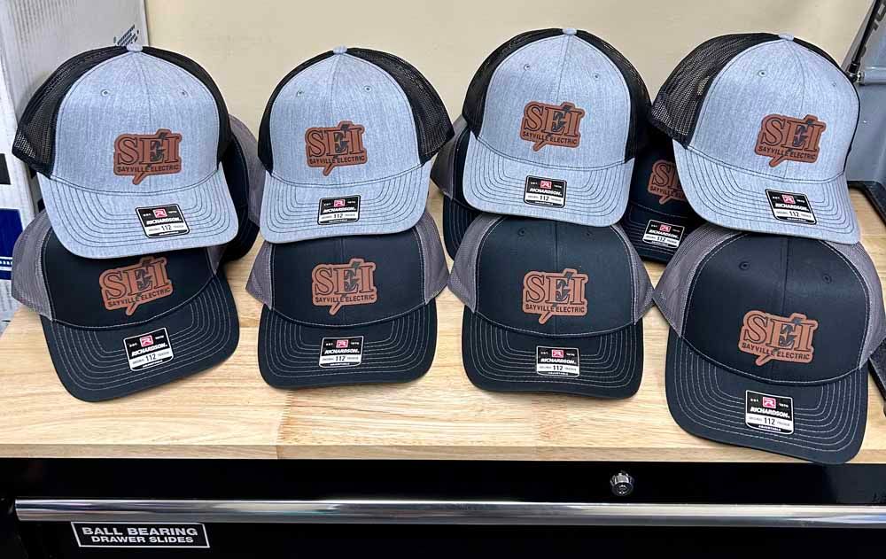 A bunch of hats are stacked on top of each other on a wooden table.