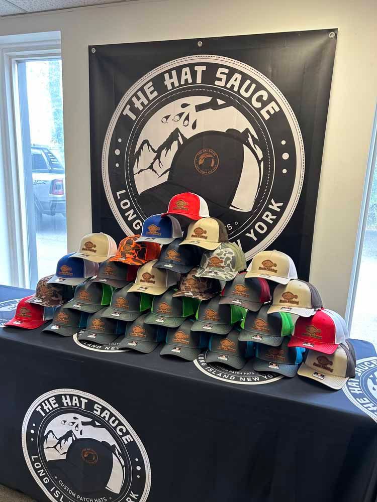 A table with a lot of hats on it in front of a sign that says the hat sauce york.