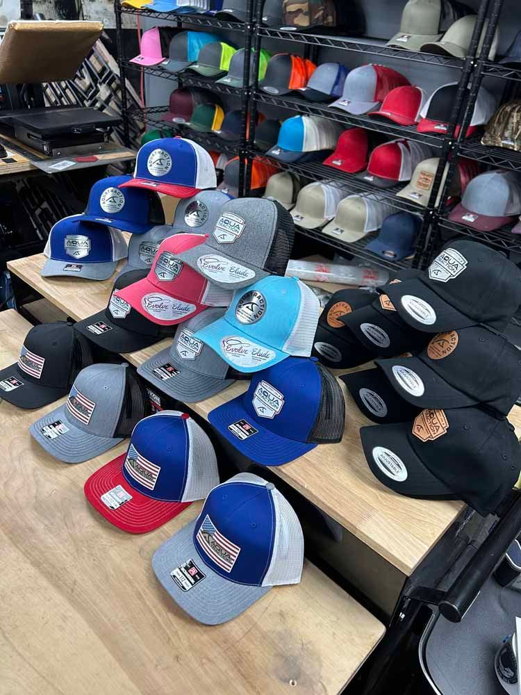 A bunch of hats are sitting on a wooden table in a store.