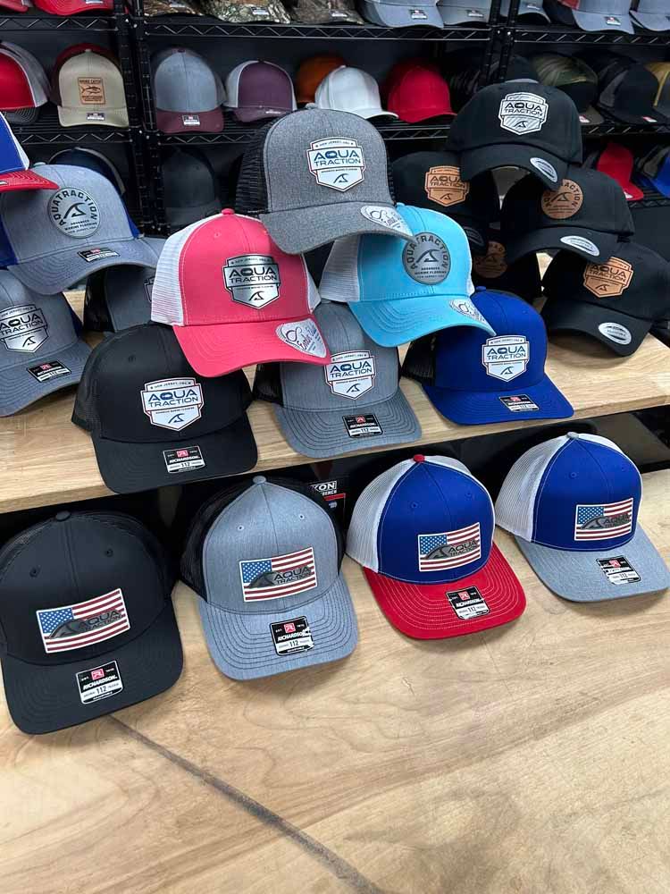 A bunch of hats are stacked on top of each other on a wooden shelf.