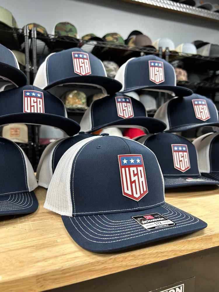 A row of baseball caps sitting on top of a wooden table.