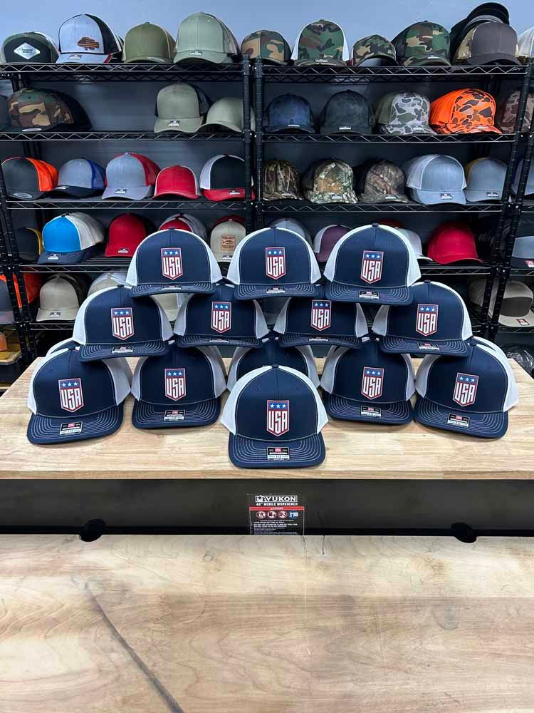 A bunch of hats are sitting on top of a wooden table in a store.