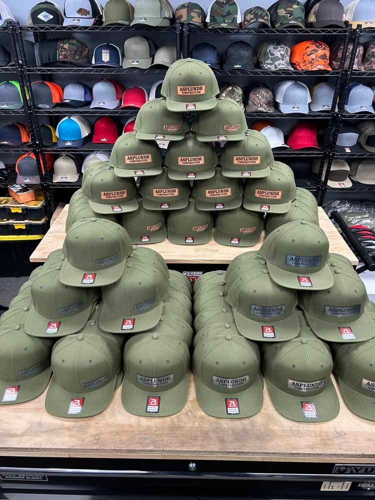 A bunch of hats are stacked on top of each other on a table in a store.